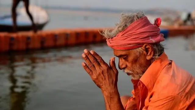 Seorang pria berdoa di depan sungai Gangga