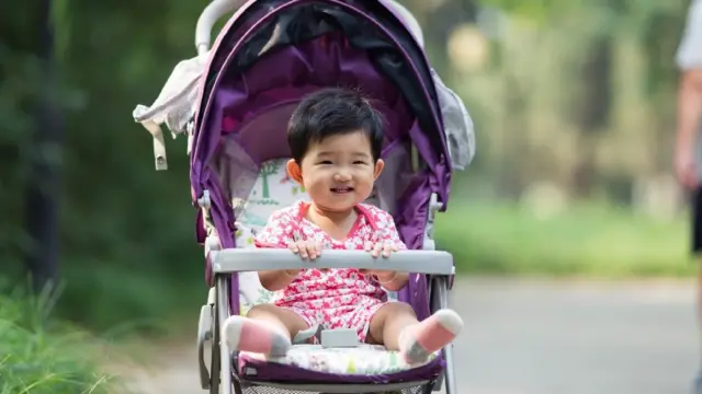 Bebê sorri enquanto está sentado1x2 pixbetcarrinho na China