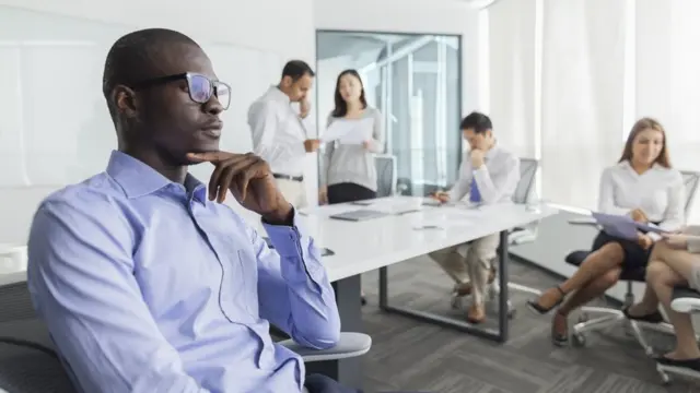 Un hombre en la oficina aislado de sus compañeros.