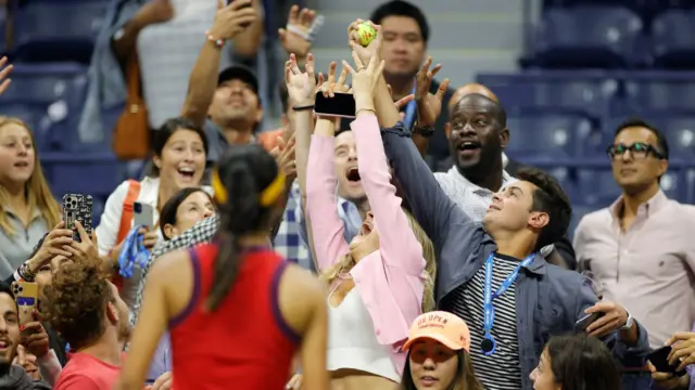 9 September: Britain's Emma Raducanu tosses a tennis ball to fans after beating Maria Sakkari to reach the US Open women's final, which she would win two days later