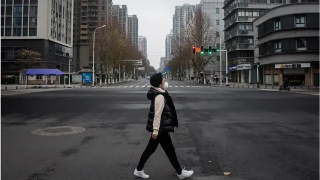 Wata mata tana tafiya a kan titin da ya yi fayau ranar 27 ga watan Janairu, 2020 a birnin Wuhan na kasar China