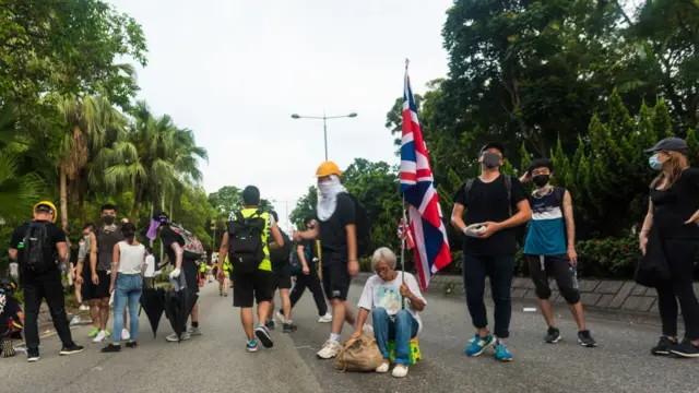 متظاهرة تعيش في شنزن تحمل علم بريطانيا في شيونغ شوي في هونغ كونغ، الصين، في 13 يوليو/تموز 2020