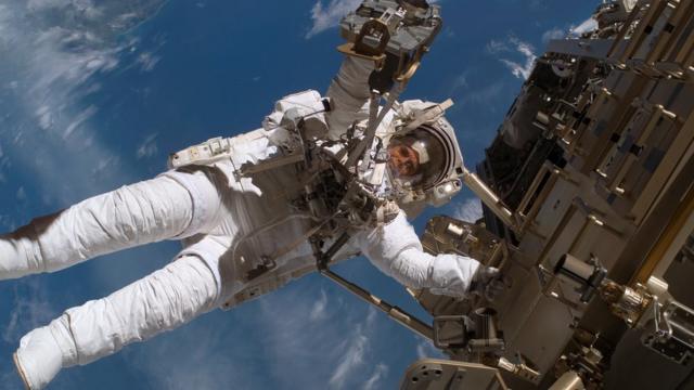 Шведский астронавт Кристер Фуглесанг выходит в открытый космос в EMU