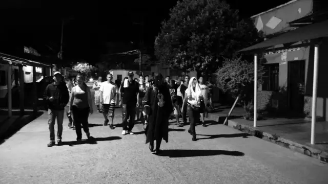 Animero y devotos caminando por las calles de Puerto Berrío.