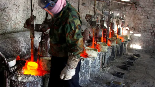 Працівник плавильного цеху в китайській Внутрішній Монголії ллє рідкісноземельний метал лантан