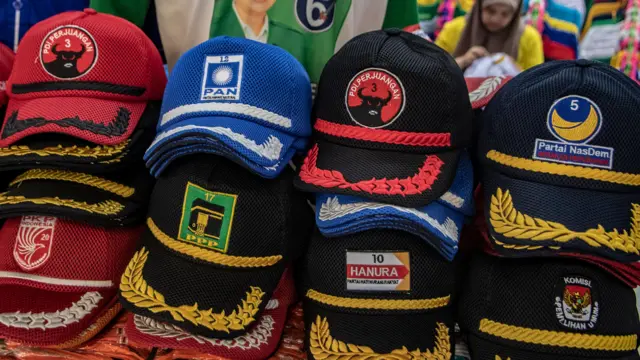 Penjual menyelesaikan pesanan atribut partai politik di Pasar Senen, Jakarta, Kamis (28/09).