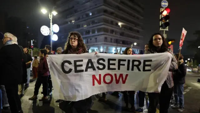 Duas mulheres segurando uma faixa pedindo um cessar-fogovalor novibet fortalezaGaza, durante uma manifestaçãovalor novibet fortalezaJerusalém.