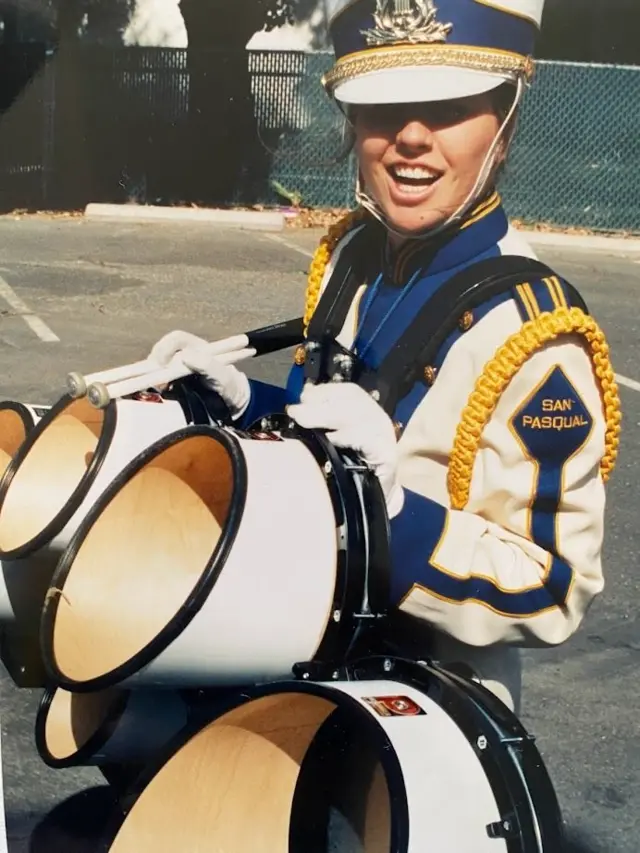 M. E. Thomas segurando instrumento musical e vestida com roupabarcelona atletico madridfanfarra