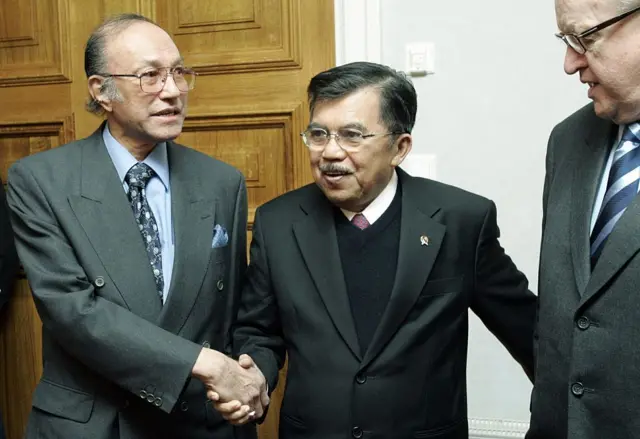 Mantan Presiden Finlandia Martti Ahtisaari (kanan), yang menengahi kesepakatan damai Aceh, berdiri bersama Wakil Presiden Indonesia Jusuf Kalla (tengah) dan perwakilan mantan pemberontak separatis Gerakan Aceh Merdeka (GAM), Malik Mahmud (kiri), pada 21 Januari 2006 di sebuah rumah besar terpencil di luar Helsinki, Finlandia, tempat perundingan damai selama tujuh bulan tersebut berlangsung secara tertutup. Tahap selanjutnya dari kesepakatan damai ini diperkirakan akan mencakup izin dari pemerintah Indonesia bagi para mantan pemberontak untuk berpartisipasi dalam pemilihan kepala daerah.