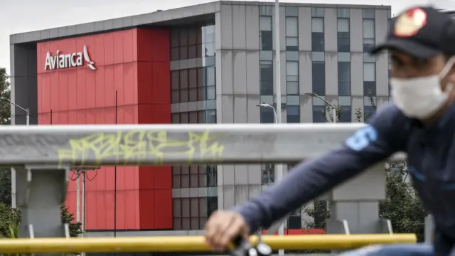 Un hombre en bicicleta con el edificio de Avianca al fondo
