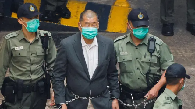 Magnat medialny Jimmy Lai, założyciel Apple Daily, idzie do więźniarki w drodze do sądu po postawieniu mu zarzutów na mocy ustawy o bezpieczeństwie narodowym, Hongkong, 12 grudnia