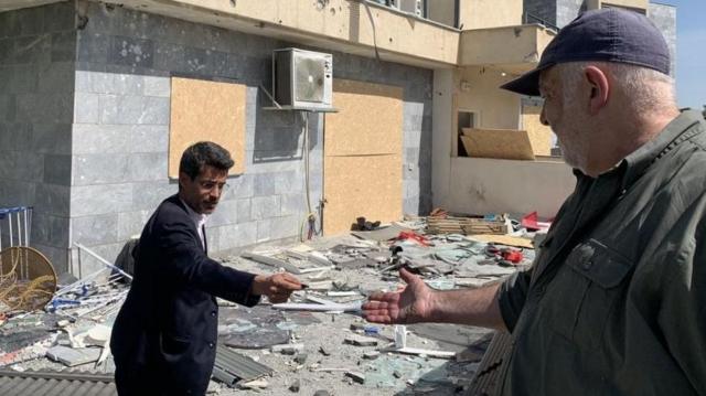 رئيس بلدية كريات شمونة، أفيخاي شتيرن، يعرض شظايا بعد غارة لحزب الله على المباني السكنية في البلدة
