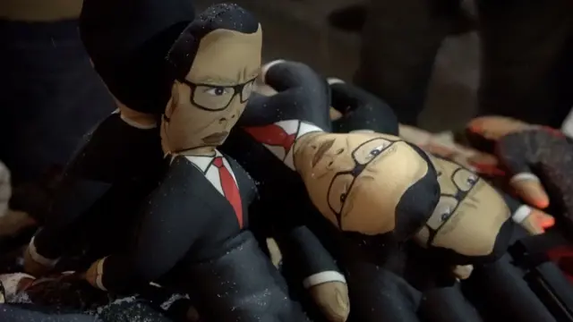 Lutke sa likom Aleksandra Vučića na štandu na kome se prodaju tokom protesta.