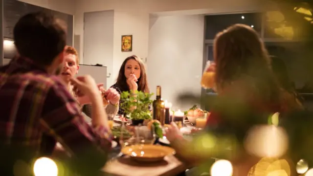 Quatro pessoas discutem sentadas à mesa