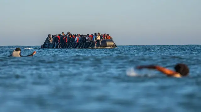یک قایق حامل مهاجران در دریا. مهاجران به شکلی فشرده در کنار هم نشستهاند و تعدادی انگشت شمار جلیقه نجات به تن دارند