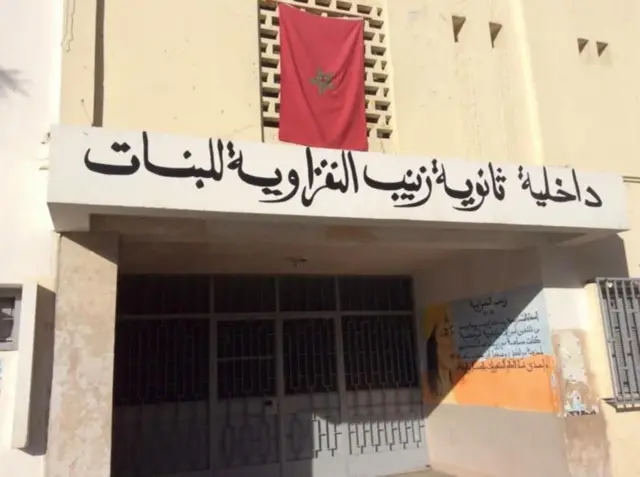 జైనబ్ అల్-నఫ్జావియా ఫోటోతో పాటు అరబిక్‌లో రాసి ఉన్న అక్షరాలు 