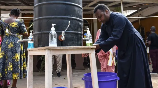 A Roman Catholic Priest washes his hands after leading Palm Sunday mass as Tanzania government allowed religious prayers despite the COVID-19 pandemic in Arusha City, northern Tanzania