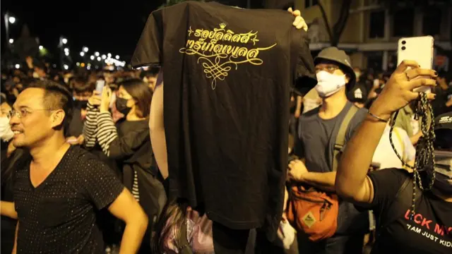 ผู้ชุมนุมชูเสื้อที่มีข้อความสกรีนว่า "รอยัลลิสต์ มาร์เก็ตเพลส"