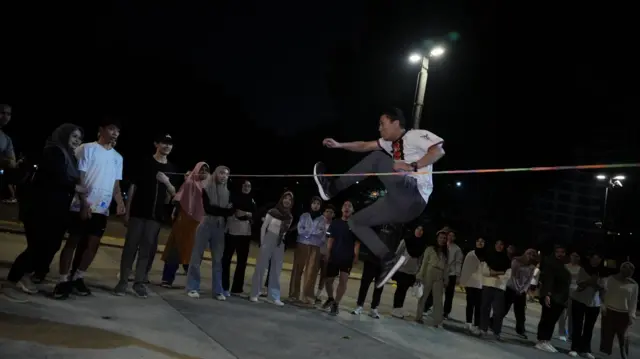 Seorang pria menjajal melompati karet 