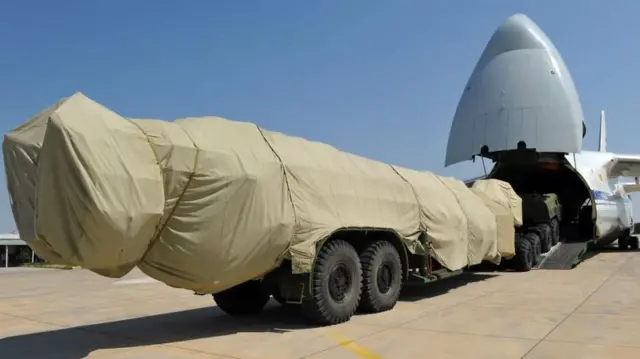 Üzeri örtülü S-400 bataryası Rus kargo uçağına yükleniyor. Sistemin yalnızca tekerlekleri görünüyor.