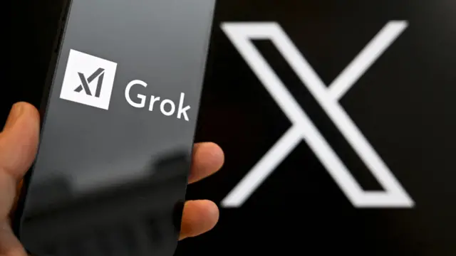 设计图片：一部展示着Grok商标的手机置于展现X商标的一面墙前面