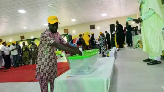 Ọkunrin kan n fi iwe idibo sinu apoti ibo, awọn eeyan pọ ni ayika rẹ