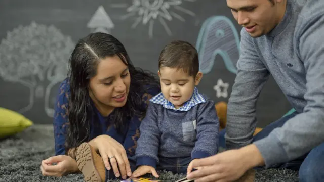 Una familia mira un libro