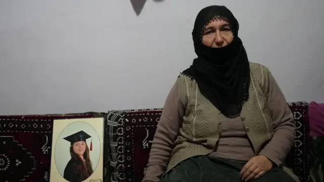 Altun Taşdemir, yangında kaybettiği kızı Nisanur Taşdemir'in fotoğrafıyla oturuyor. 