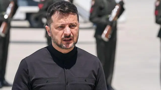 Zelensky look into di air on white cloth