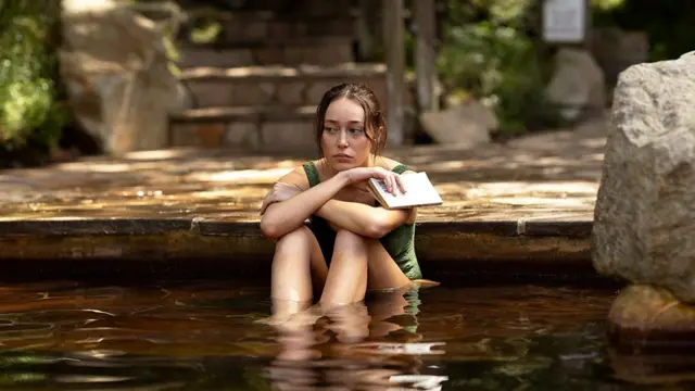 Alycia Debnam-Carey sentada em uma área alada em trecho da série da Netflix