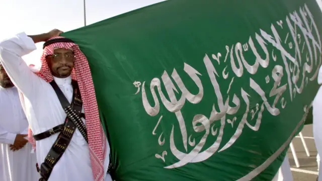 A Saudi policeman holds up a flag