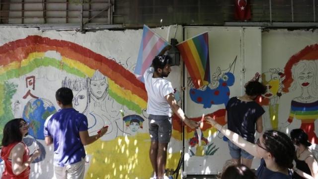 نشطاء يرسمون جداريات بألوان قوس قزح قبل تنظيم المسيرة السنوية