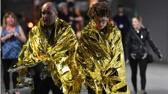 Personas con mantas térmicas tras los ataques.