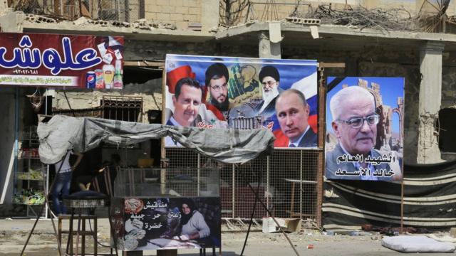 Portraits of (from L to R), Syrian President Bashar al-Assad, Lebanon's Hezbollah chief Hasan Nasrallah, Iran's supreme leader Ayatollah Ali Khamenei, Russian President Vladimir Putin and Khaled al-Assaad, the slain chief archaeologist of the ancient Syrian city of Palmyra, are seen in the eastern city of Deir Ezzor on September 20, 2017 as Syrian government forces continue to press forward with Russian air cover in the offensive against Islamic State group jihadists across the province. Two separate offensives are under way against the jihadists in the area -- one by the US-backed Syrian Democratic Forces, the other by Russian-backed government forces. The Syrian army now controls around 70 percent of the city and is battling to oust IS from the remainder, according to the Britain-based Observatory. / AFP PHOTO / LOUAI BESHARA (Photo credit should read LOUAI BESHARA/AFP/Getty Images)