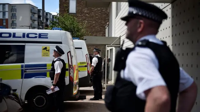 Police standing guard at a block of flats in Barking