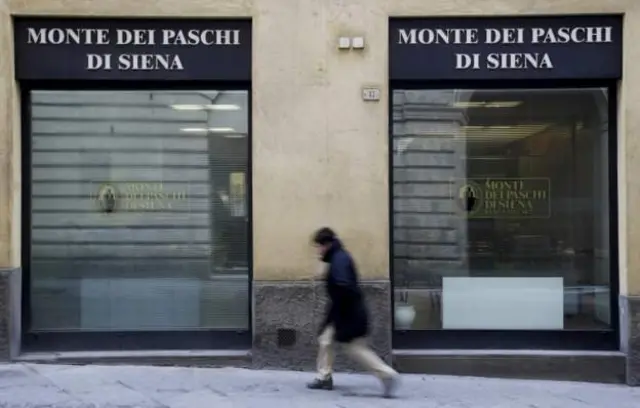 Local de Monte Dei Paschi de Siena con un transeúnte frente las puertas cerradas.