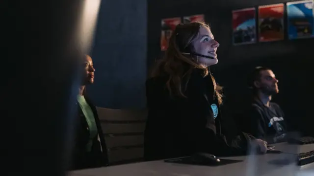 Pessoas no interior de um centro de comando espacial. 