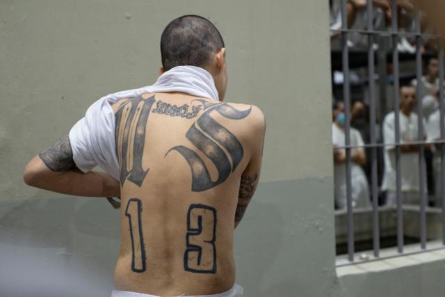 Un reo muestra su espalda tatuada con los símbolos de la Mara Salvatrucha