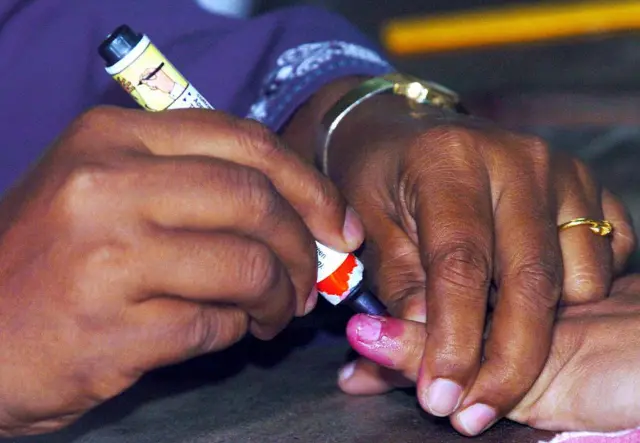 A Sri Lankan election official (L) marks a voter's finger with indelible ink as a sign of voting at a polling booth in Colombo 02 April 2004. Voting got underway in Sri Lanka for the third parliamentary election in four years to elect Sri Lanka's 13th parliament since independence from Britain in 1948. The vote was called by President Chandrika Kumaratunga after she disagreed with Premier Wickremesinghe over his handling of a Norwegian-backed bid to end ethnic bloodshed and conflict that has claimed more than 60,000 lives since 1972. AFP PHOTO/Indranil MUKHERJEE (Photo credit should read INDRANIL MUKHERJEE/AFP via Getty Images)
