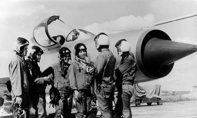 Các phi công của lực lượng Không quân Bắc Việt đứng cạnh chiếc MiG-21 Các phi công của lực lượng Không quân Bắc Việt đứng cạnh chiếc MiG-21