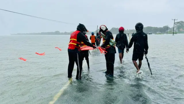 නන්දිකඩාල් කලපුව අසල මාර්ගයෙන් ජලයෙන් යටවීම නිසා මාර්ග සංවර්ධන දෙපාර්තමේන්තුවේ නිලධාරීන් අනතුරු ඇඟවීම සඳහා සංඥා යොදවමින් 