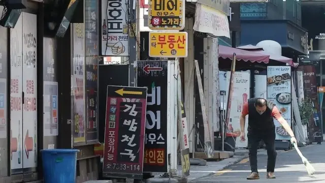 가게 앞을 청소하는 남성