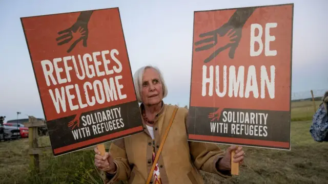 Una mujer protesta contra la deportación de solicitantes de asilo en Reino Unido a Ruanda.