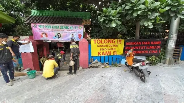 Sekolah Dasar Negeri Pondok Cina 1 ramai diperbincangkan publik setelah video yang memperlihatkan akses masuknya terhalang pembangunan trotoar Jalan Margonda Raya viral di media sosial. 