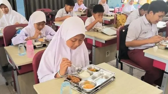 Siswa Sekolah Dasar (SD) Negeri 064965 di Kota Medan, Sumut, menikmati makan bergizi gratis. Menu pada hari kedua: nasi, ayam goreng tepung, sayur wortel, dan buah.