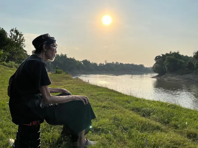 seniman sandur bojonegoro sedang duduk di tepi sungai