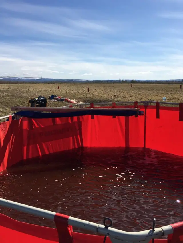 Oil and water pumped from the rivers inside a container
