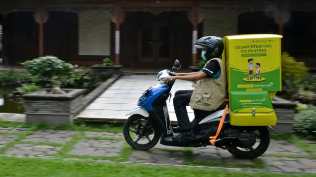 Relawan mengantarkan olahan makanan bergizi dengan Motor Gizi Makanan Sarat Gizi (Mozi Masagi) di Tarogong Kidul, Kabupaten Garut, Jawa Barat, Rabu (10/9/2021).