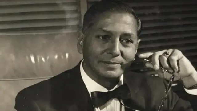 یو سړی عینکي په لاس کې ناست دی