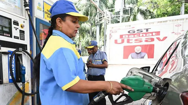 एक पेट्रोल पंप पर गाड़ी में पेट्रोल भरती पंप का कर्मचारी